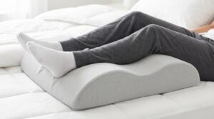 Three different types of wedge pillow designs arranged on a bed.